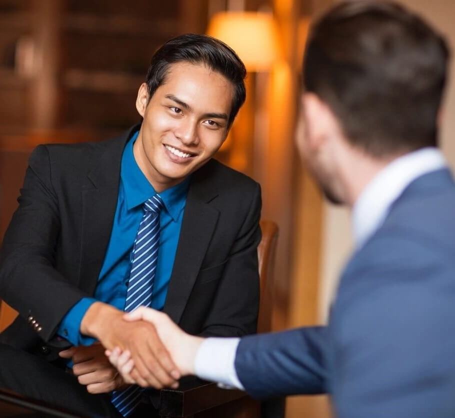 Two men shaking hands in a restaurant.